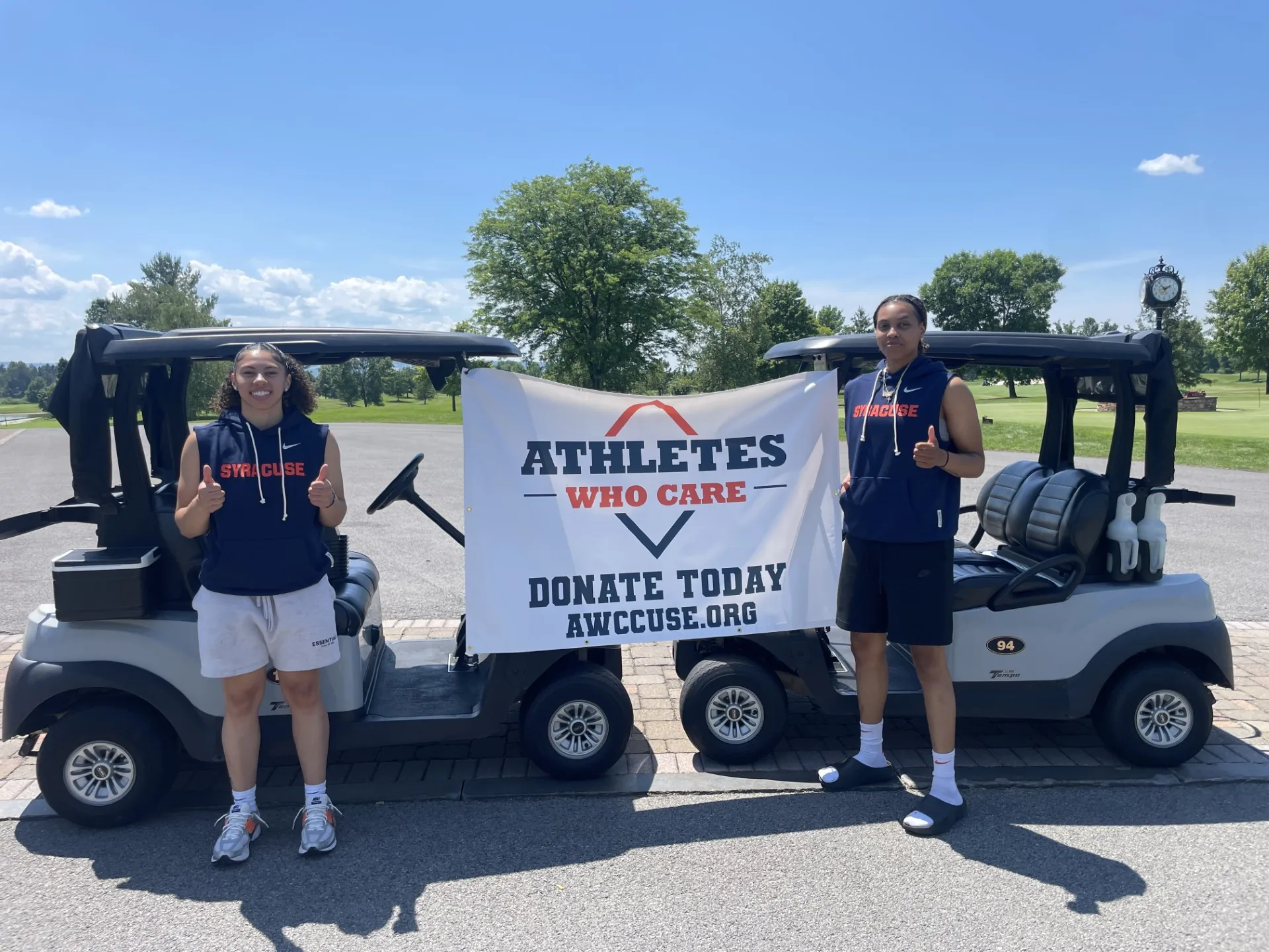 Syracuse student-athletes with an Athletes Who Care banner at the golf outing